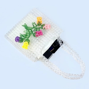 Detail of handmade beaded bag with colorful floral patterns and interior capacity display