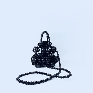 Detail of black beaded handbag with velvet drawstring pouch and matching shoulder strap