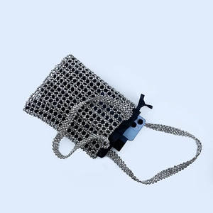 Top view of silver beaded handbag showing internal capacity with a smartphone inside
