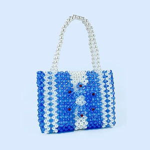 Détail de perles en acrylique faites à la main sur le sac à main carré tissé à fleurs