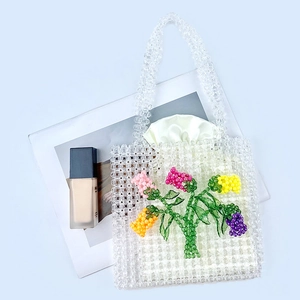 Detail of handmade acrylic beaded bag with 3D colorful flowers and satin drawstring liner
