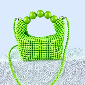 Detail of green handmade beaded handbag with large round beads and silver buckles