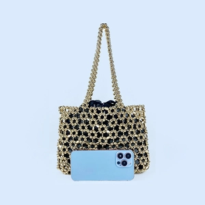 Detailed view of handmade gold beaded hollow bag with black satin inner drawstring pouch