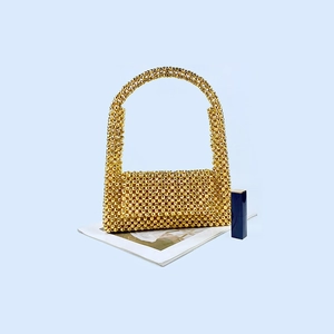 Détail de sac à main tissé avec perles dorées métalliques et texture artisanale