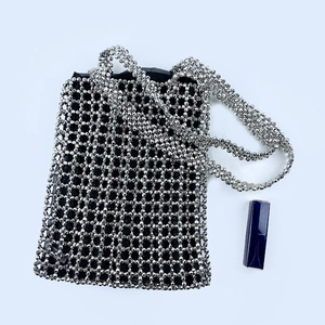 Close-up of handmade silver metallic beaded bag with dense mesh structure and black lining