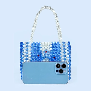 Détail du mini sac perlé fait main avec motif floral bleu et poignée en perles