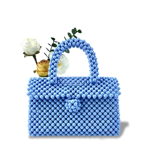 Detail of light blue handmade beaded handbag with high-gloss beads and floral decor