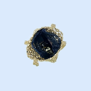 Detail view of gold beaded handbag with black lining showing interior storage capacity