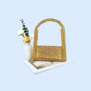 Vue détaillée de la texture du sac à main en perles dorées avec perles métalliques
