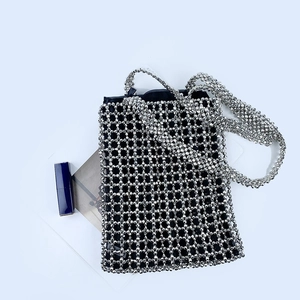 Detailed shot of handmade silver beaded handbag with black inner lining and shoulder strap