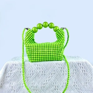 Detailed macro view of a lime green handmade beaded handbag with artistic large beads