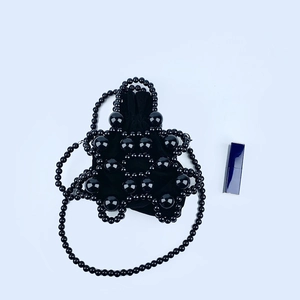Detail of black beaded star bag with drawstring velvet pouch and elegant shoulder strap
