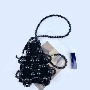 Detail of hand-woven black beaded evening bag with velvet drawstring liner and strap