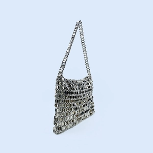 Detail view of the hand-woven silver metal sequin shoulder bag showing chainmail texture
