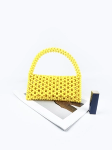 Bright yellow handmade beaded handbag with flip cover and stylish woven handle