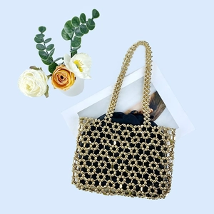 Detail of handmade gold metallic beaded bag with hollow honeycomb mesh and inner pouch