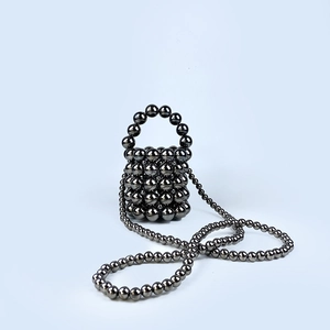 Close-up of metallic gunmetal beaded mini bucket bag with crossbody strap and handle