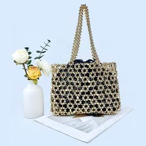 Detail of golden beaded handbag with hollow mesh structure and black inner lining bag