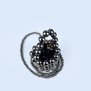 Close-up of handmade dark gray metallic beaded mini bucket bag with glossy round pearls