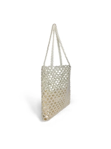 Detailed close-up of the woven pearl mesh and satin lining on a white shoulder bag