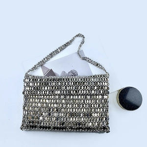 Detailed macro view of silver metallic sequin mesh fabric on a stylish handbag