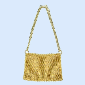 Detail of handcrafted gold metal chain link handbag with shimmering mesh texture