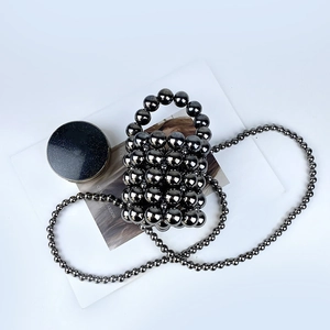 Detailed view of handmade bucket bag with dark grey metallic beads and chain strap