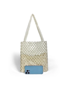 Close-up of handmade pearl woven handbag with champagne satin lining and blue phone for scale