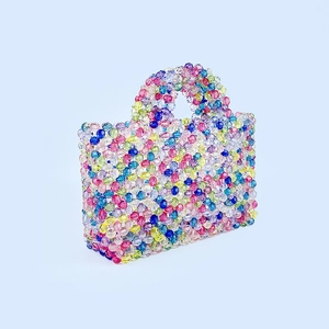 Detail of a handmade colorful beaded mini tote with transparent rainbow beads and handle