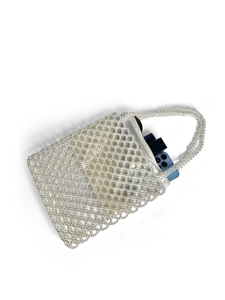 Detail of handmade pearl beaded bag with zip closure showing interior storage capacity