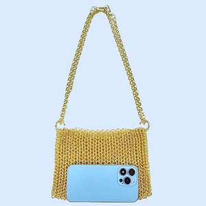 Detail of gold metal mesh bag with interlocking rings and long chain shoulder strap