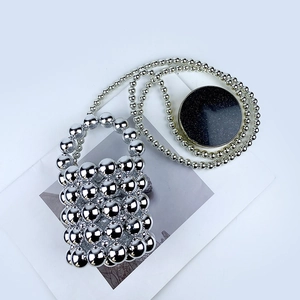 Detail of silver mirrored beaded mini bucket bag with metallic luster and chain strap