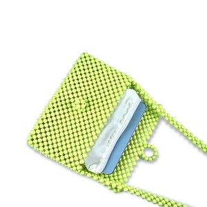Detail view of green beaded bag interior showing capacity for a smartphone