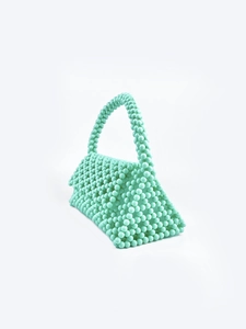 Detailed view of mint green handmade beaded handbag with a structured trapezoid design