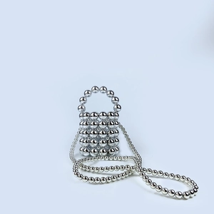 Detail of silver handmade beaded mini bucket bag with pearl handle and long chain strap