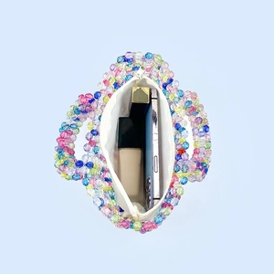 Detail of rainbow heart beaded bag showing white lining and interior storage capacity