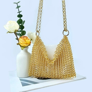 Detailed view of handmade gold metal mesh handbag with intricate chainmail weaving texture