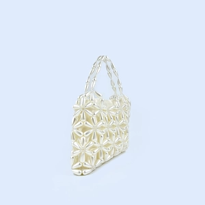Detail of handcrafted pearl beaded handbag with floral pattern and silk lining
