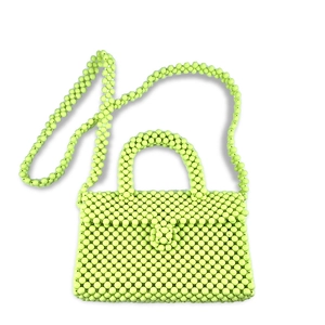 Detail view of lime green beaded handbag showing circular acrylic beads and handwoven texture