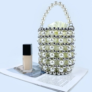 Detailed view of woven pearl bucket bag with metallic beads and satin drawstring inner pouch