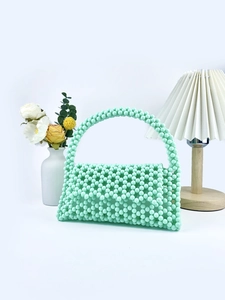 Detail of mint green beaded handbag with handmade weave texture and top handle