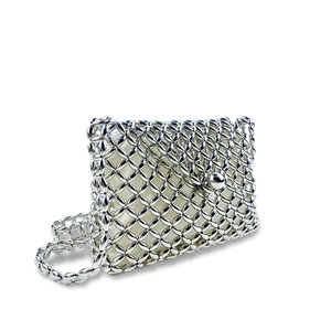 Macro shot of silver metal beaded woven bag with intricate grid pattern and snap closure