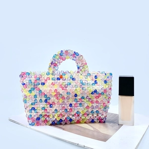 Detail of colorful handmade beaded bag with vibrant translucent rainbow beads and handles
