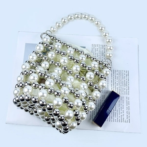 Detail of beaded pearl bucket bag showing woven texture and inner satin lining