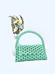 Detail of mint green beaded handbag with handmade woven texture and top handle flap design