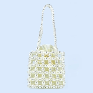 Detail of handmade pearl beaded handbag featuring cream satin drawstring lining and texture