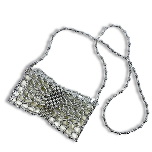 Detailed close-up of a silver woven metal mini bag with shiny beads and chain strap