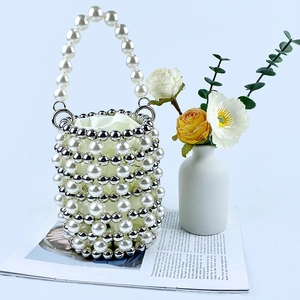 Detail of hand-woven pearl bucket bag with silver beads and elegant satin lining inside