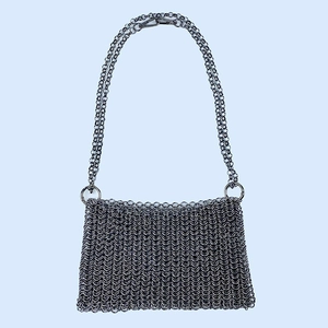 Macro detail of the hand-woven silver metal chain and interlocking rings on this crossbody bag