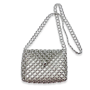 Detail of silver metallic woven crossbody bag with round bead texture and spherical lock